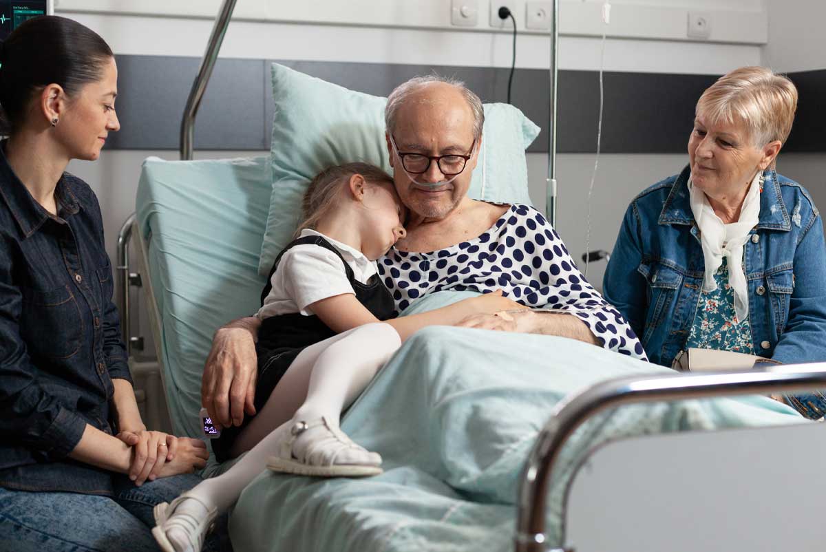 Une famille à l'hôpital entourant un senior. Sa femme peut demander l'action sociale ASIR