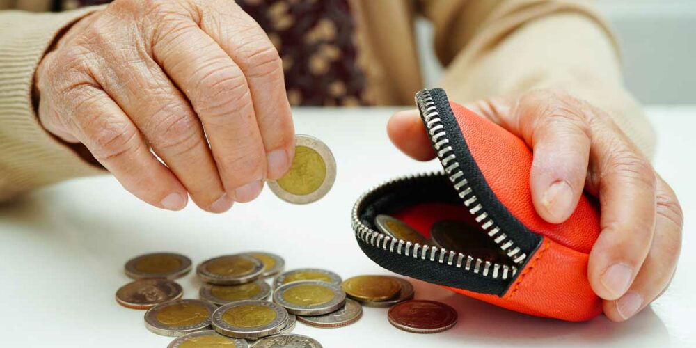 Une dame senior comptant son argent et qui a besoin de l'aide ASPA