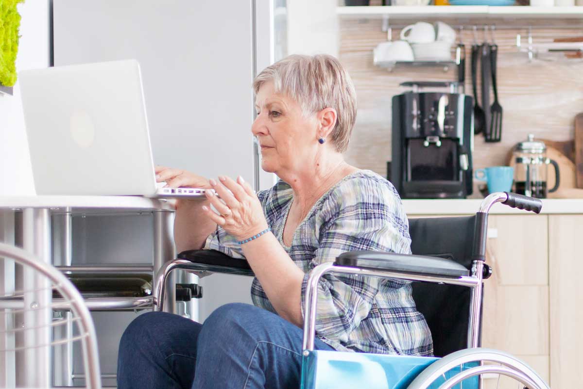 Une femme en retraite calcule le montant de son AAH sur un ordinateur