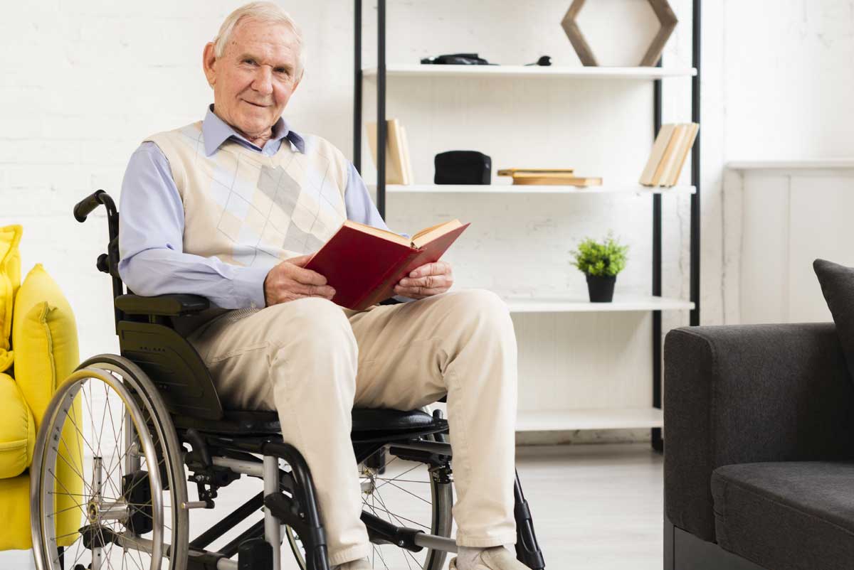 Un retraité en fauteuil de roulant, bénéficiaire d'une pension d'invalidité, lisant un livre