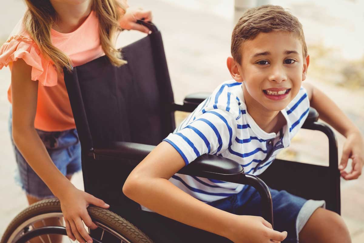 Un enfant dans son fauteuil roulant bénéficiaire de l'AEEH