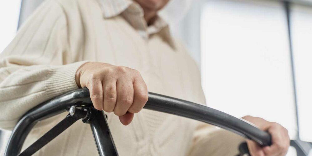 Une femme senior avec son déambulateur peut bénéficier des avantages donnés par la Loi handicap