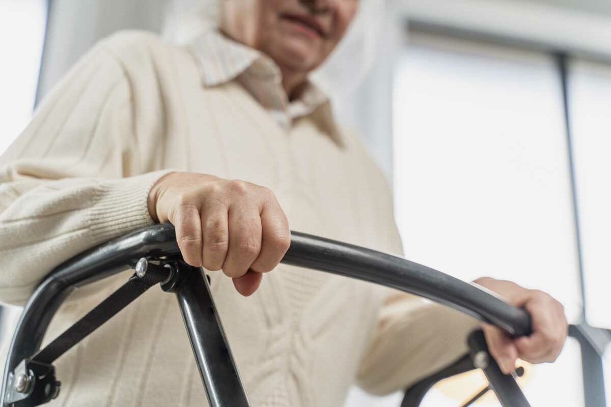 Une femme senior avec son déambulateur peut bénéficier des avantages donnés par la Loi handicap