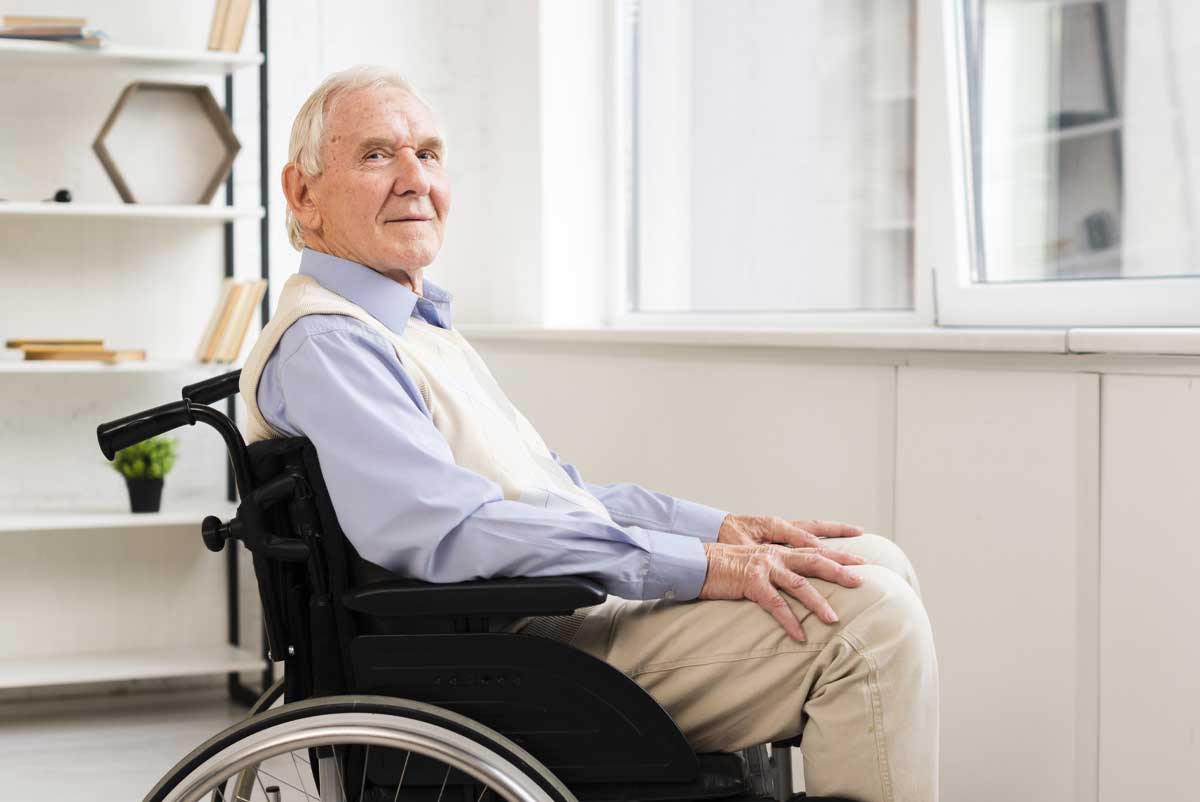 Un senior en situation de handicap, dans son fauteuil roulant, chez lui