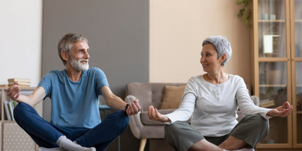 Un couple de seniors qui font du yoga ensemble