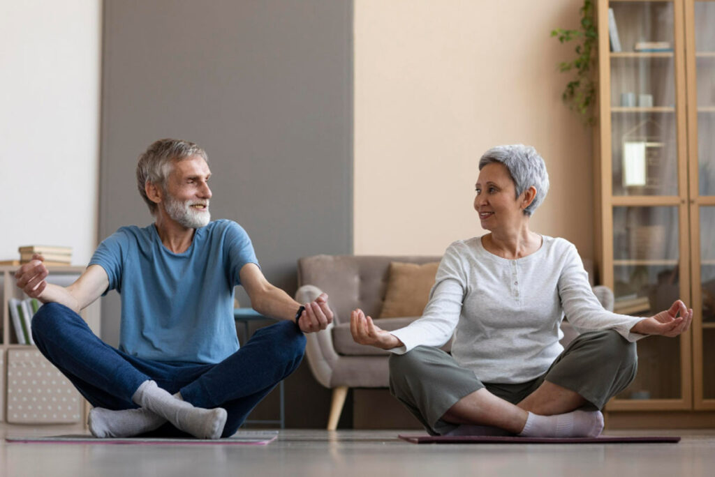 Un couple de seniors qui font du yoga ensemble