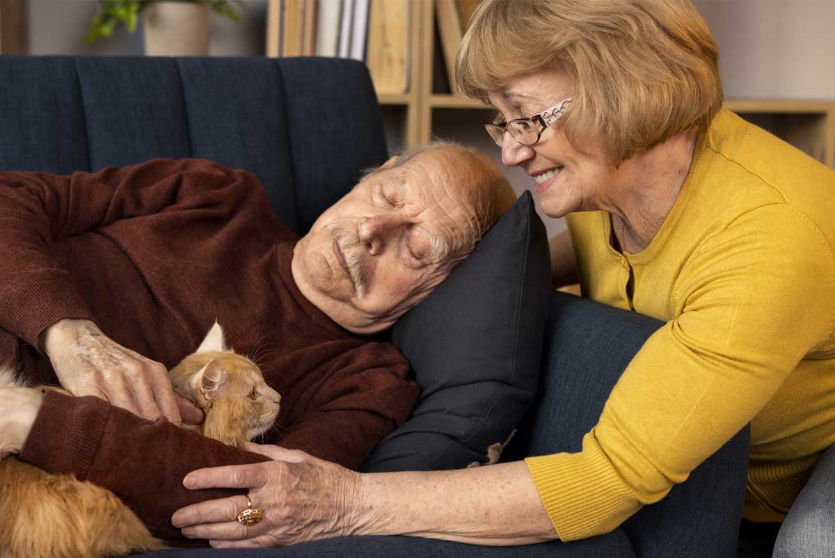 Une femme pair-aidant de son mari, en train de dormir avec leur chat dans les bras