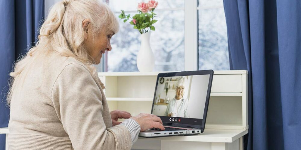 Femme utilisant une application de visioconférence simplifiée pour senior