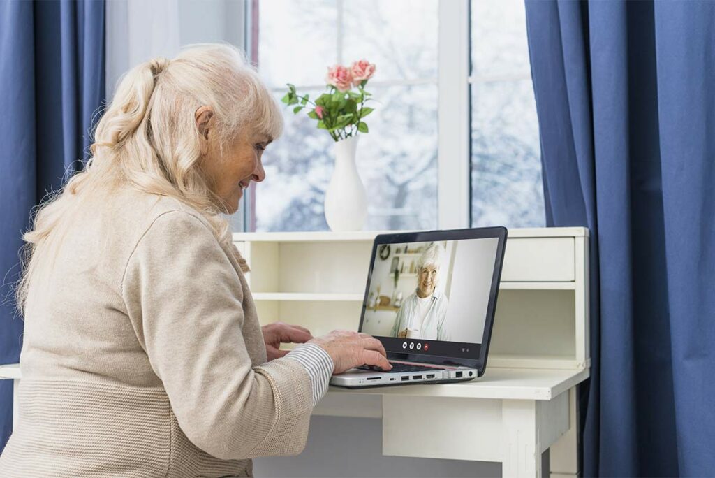 Femme utilisant une application de visioconférence simplifiée pour senior