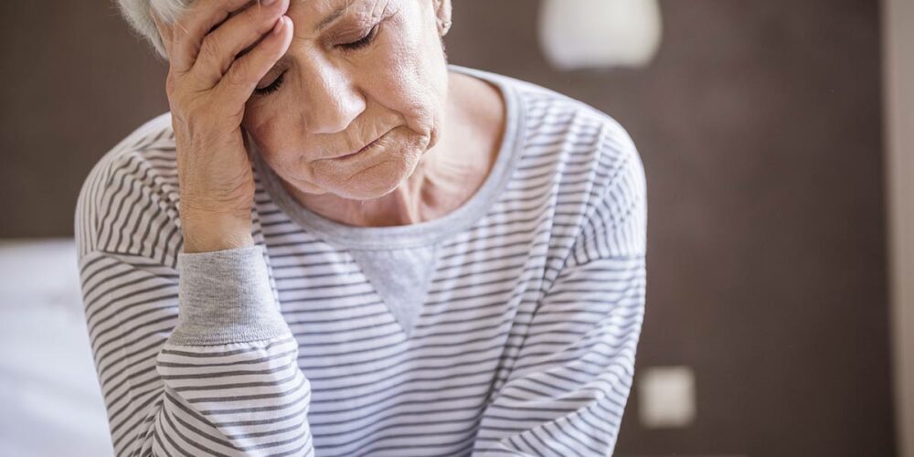 Femme qui ressent les signes d'un AVC : vertiges, maux de tête.