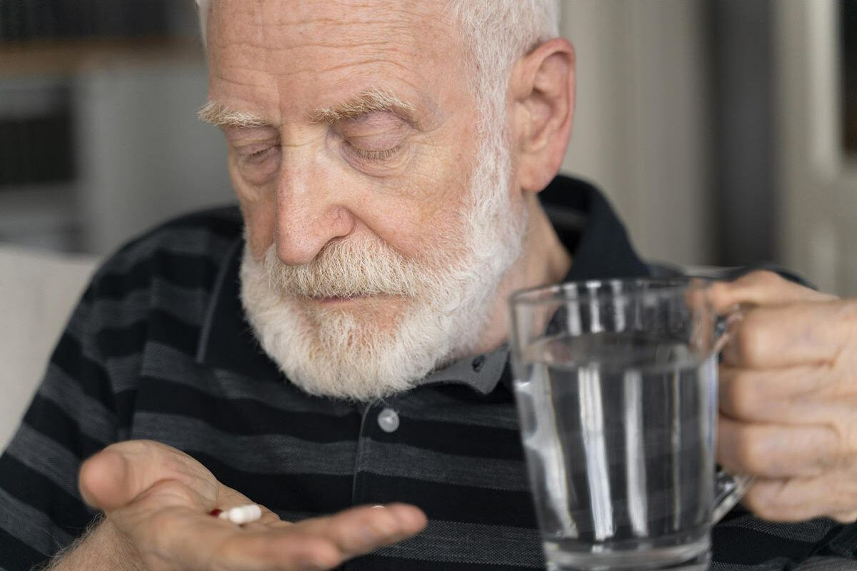 Senior regardant un cachet de morphine dans sa main