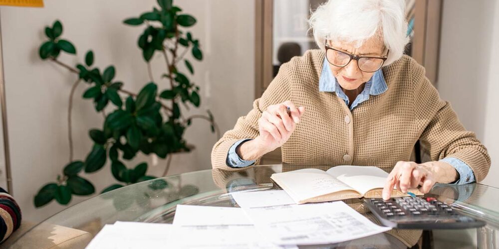 Senior calculant ses impôts après le crédit d'impôt accordé sur la téléassistance