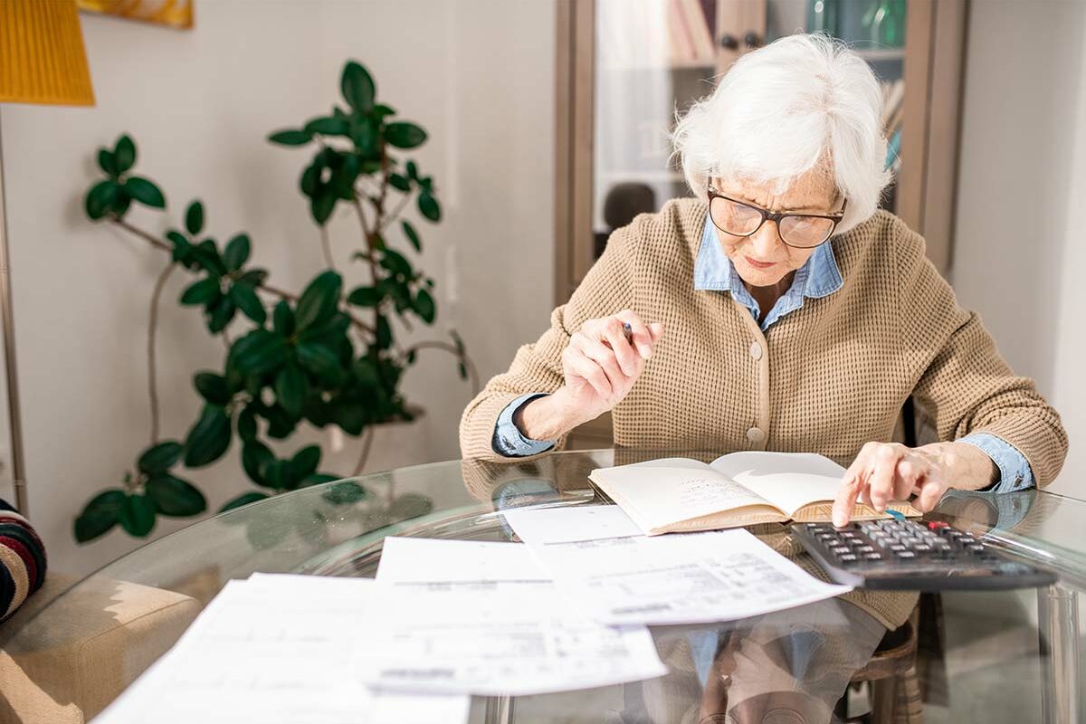 Senior calculant ses impôts après le crédit d'impôt accordé sur la téléassistance
